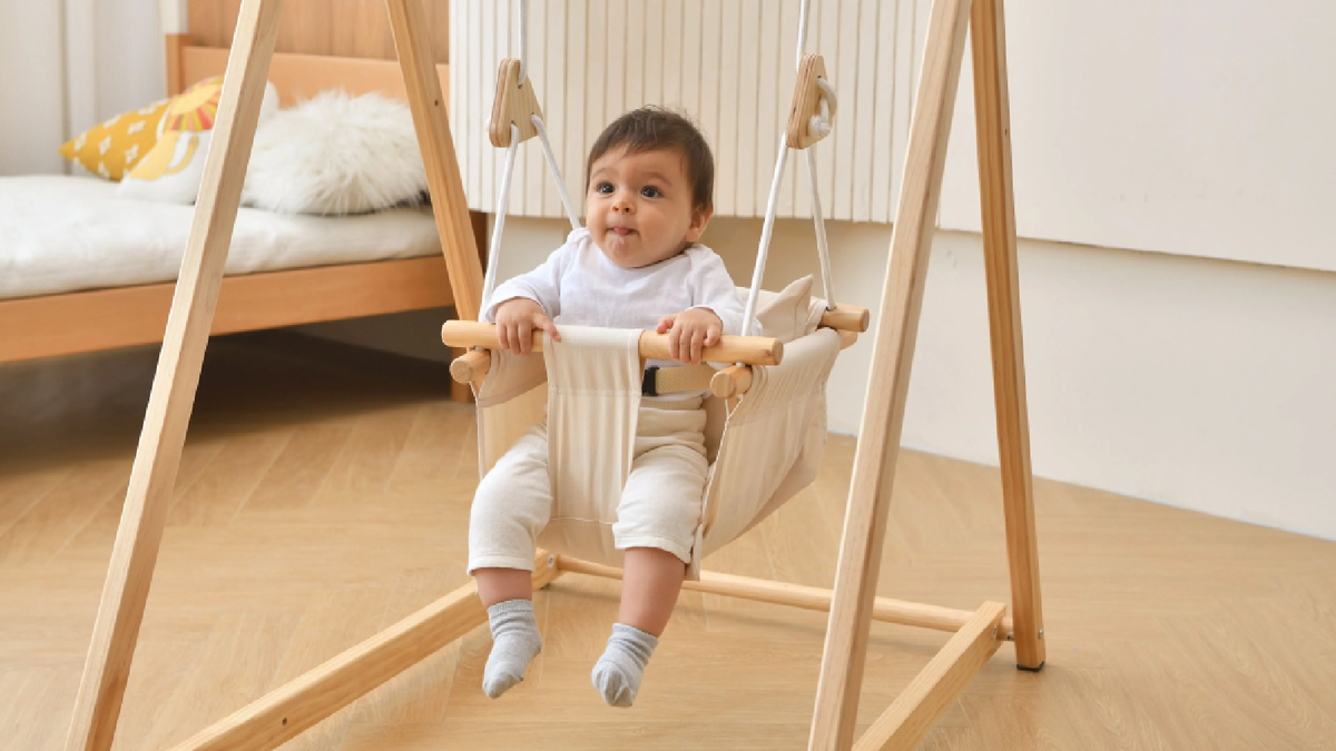 Child on the Avenlur Spruce wooden indoor swing
