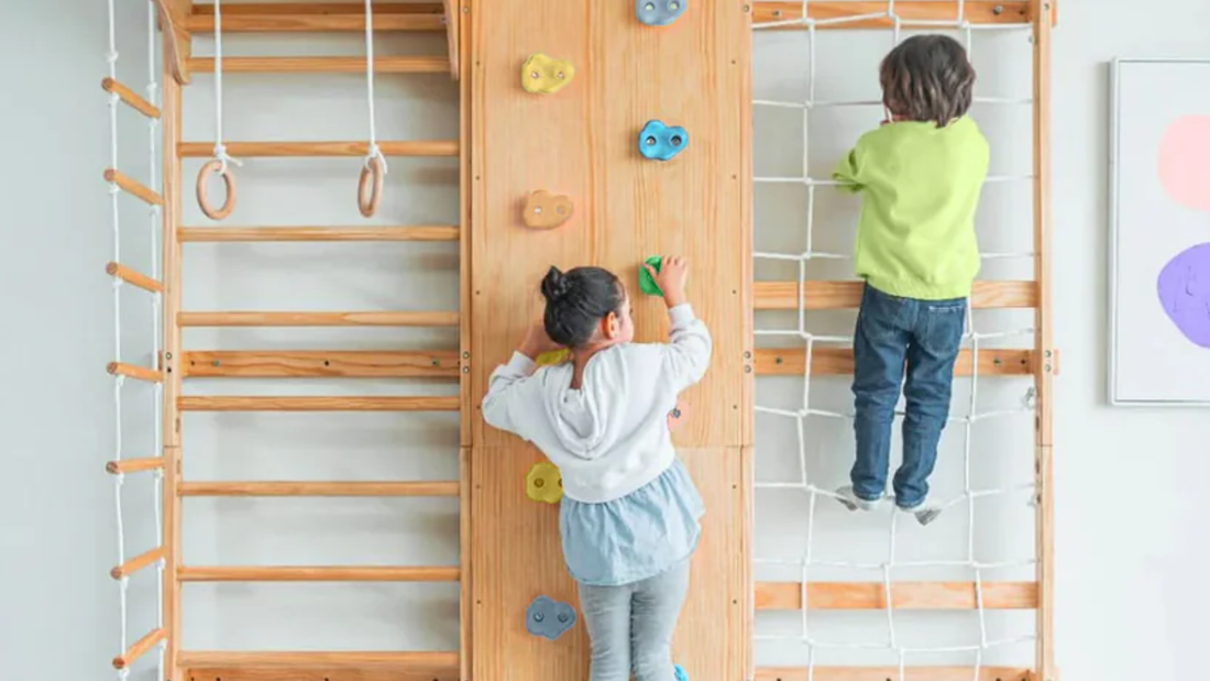 Two children climbing the rock wall and rope net of an Avenlur Walnut climbing wall