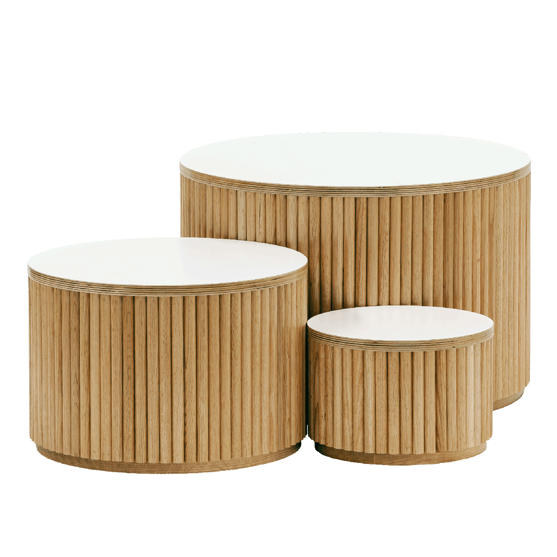 Set of three round wooden tables with white tops on a white background