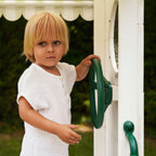 Child using the steering wheel pretend play panel on the Avenlur Aloe playhouse