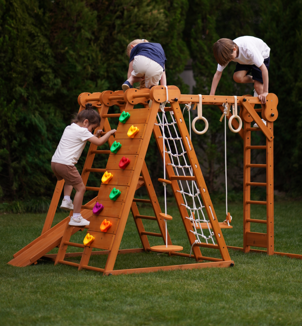 Avenlur Chestnut playset features: slide, climbing wall, net, swing and bars