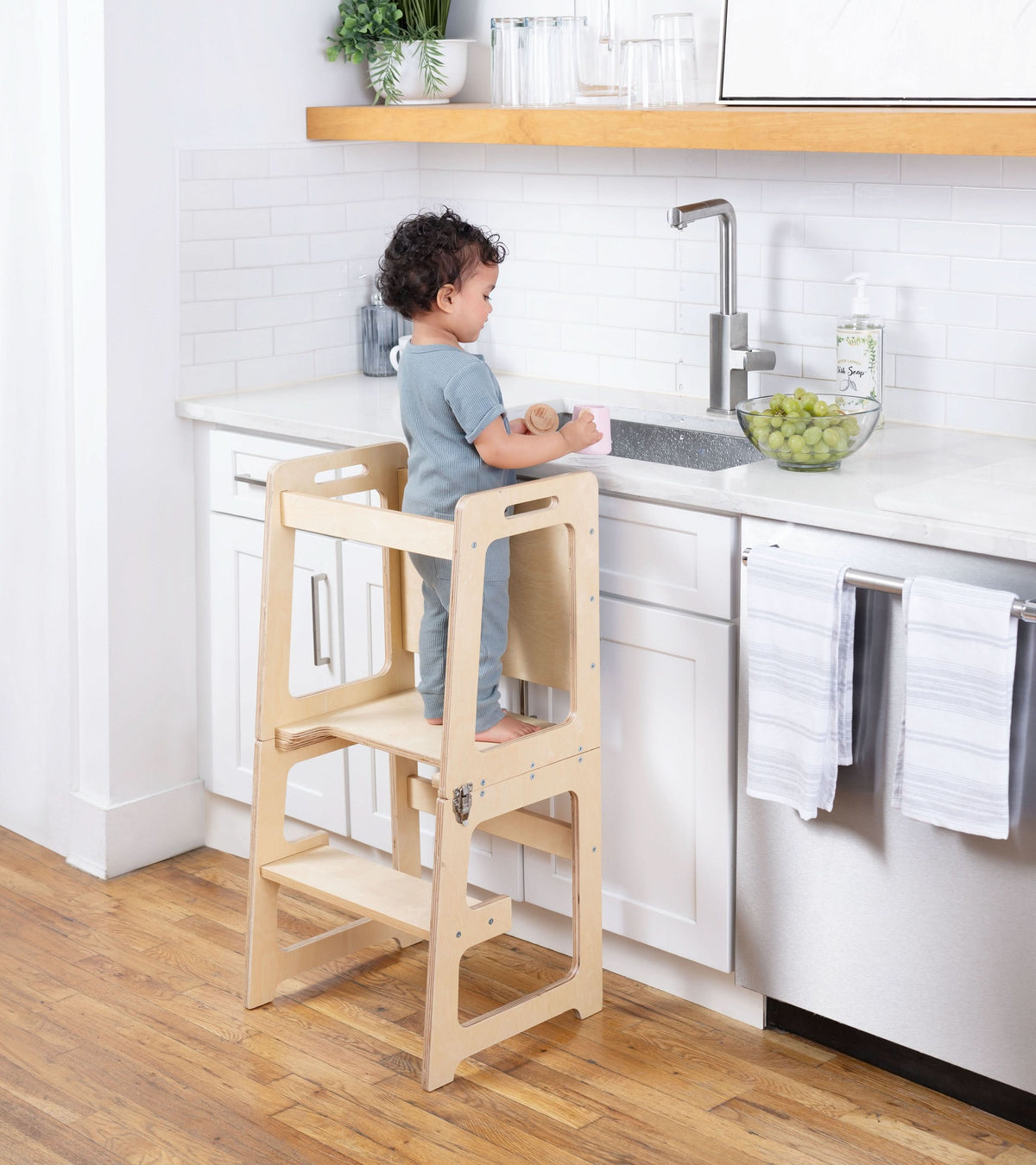 Toddler standing in the Avenlur Date kitchen tower at the counter