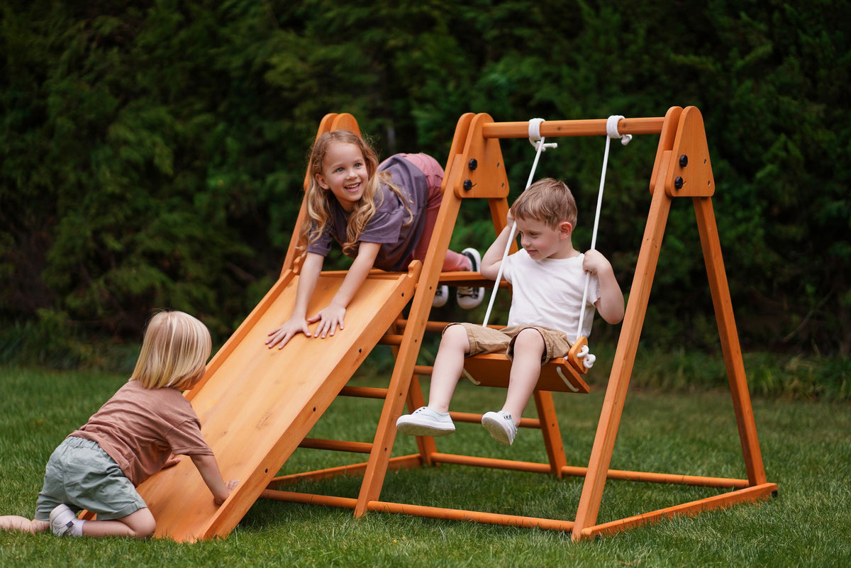 Toddler climbing the Avenlur Juniper backyard climber on the grass