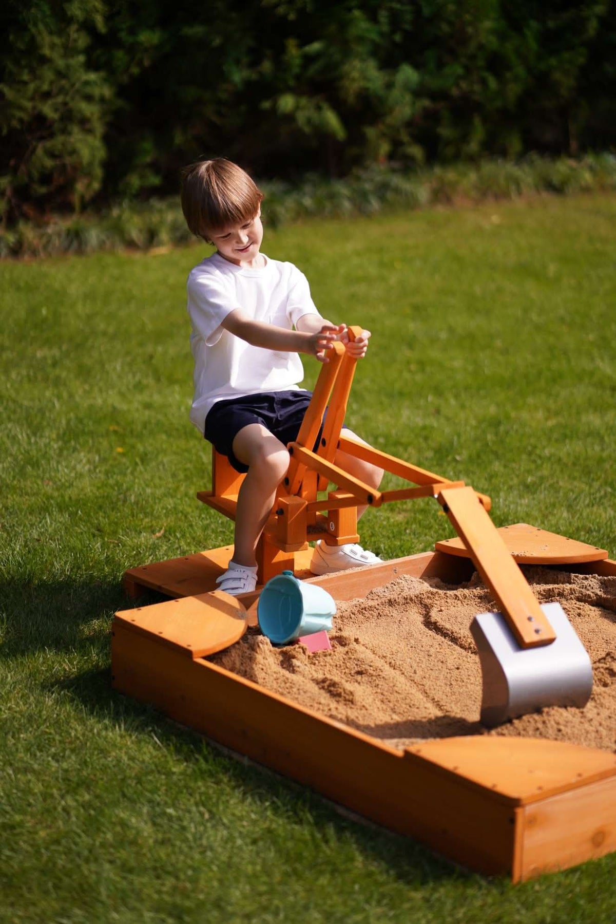 Child digging in a sandbox with the Avenlur ride-on excavator