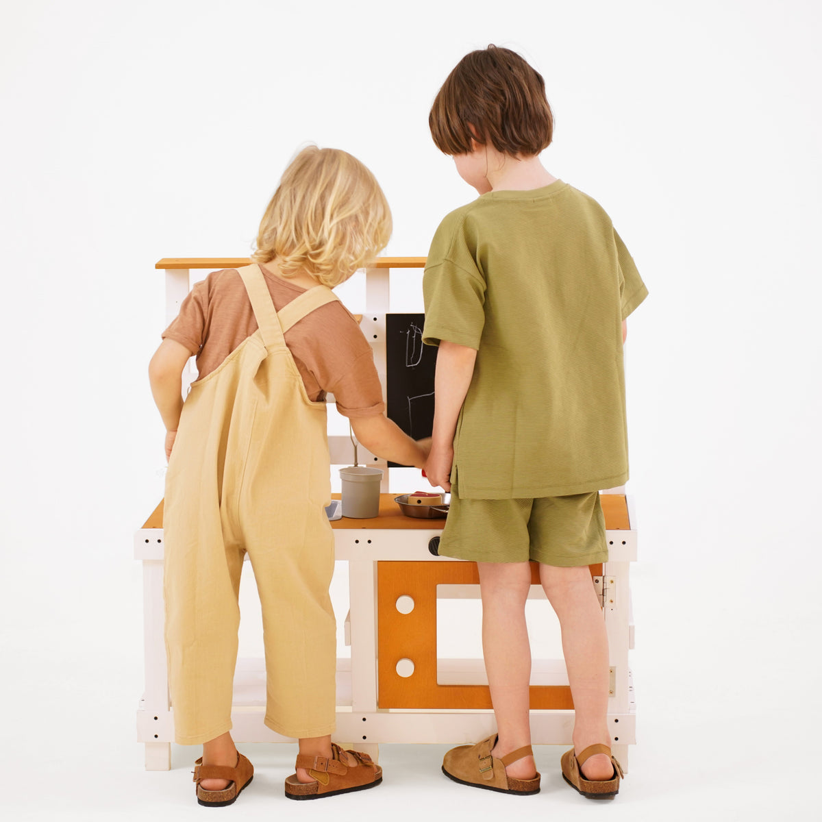 Child washing toys in the Avenlur Woodland mud kitchen sink