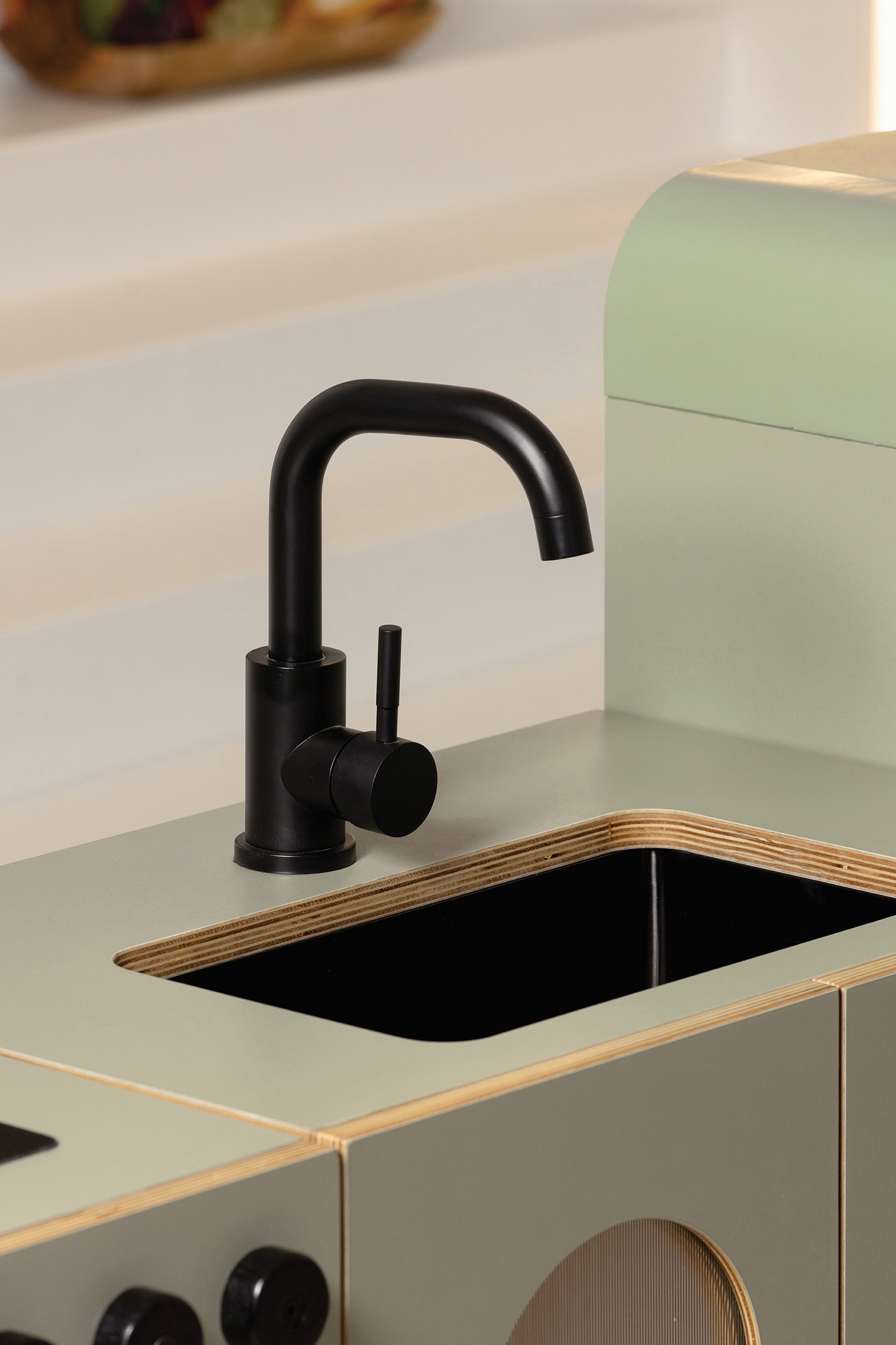 Detail of the matte black faucet and basin on the Sage Fluted play sink