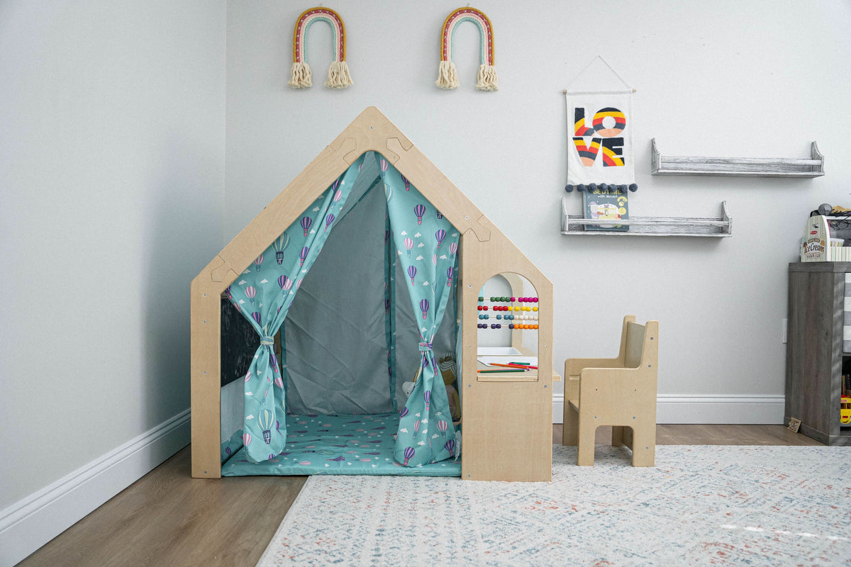 Child drawing at the desk inside the Avenlur Flair wooden playhouse