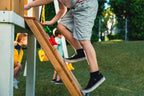 Side view of the Avenlur Forest swing set rock wall