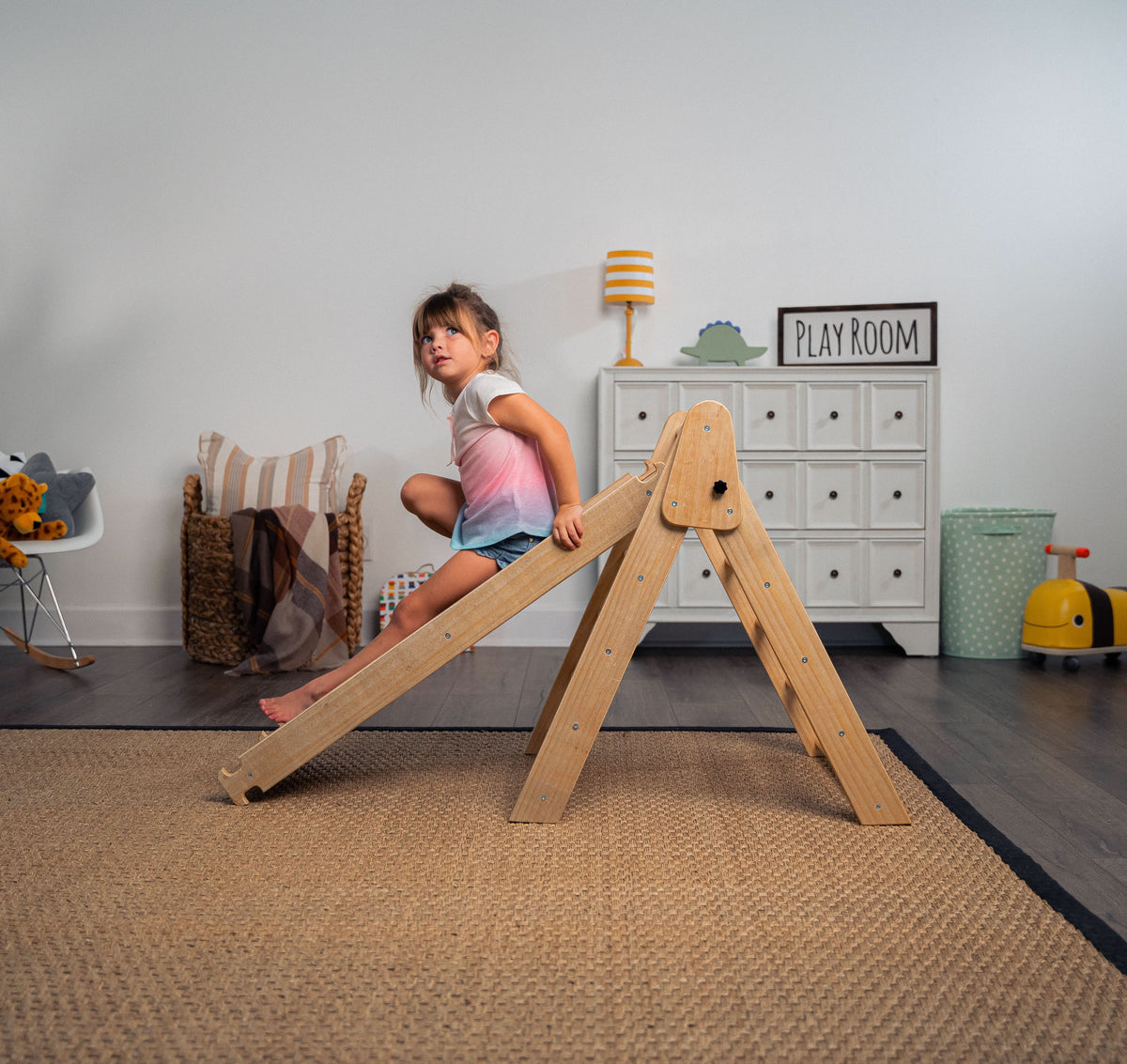 Toddler on the Avenlur Hazel climbing triangle at home