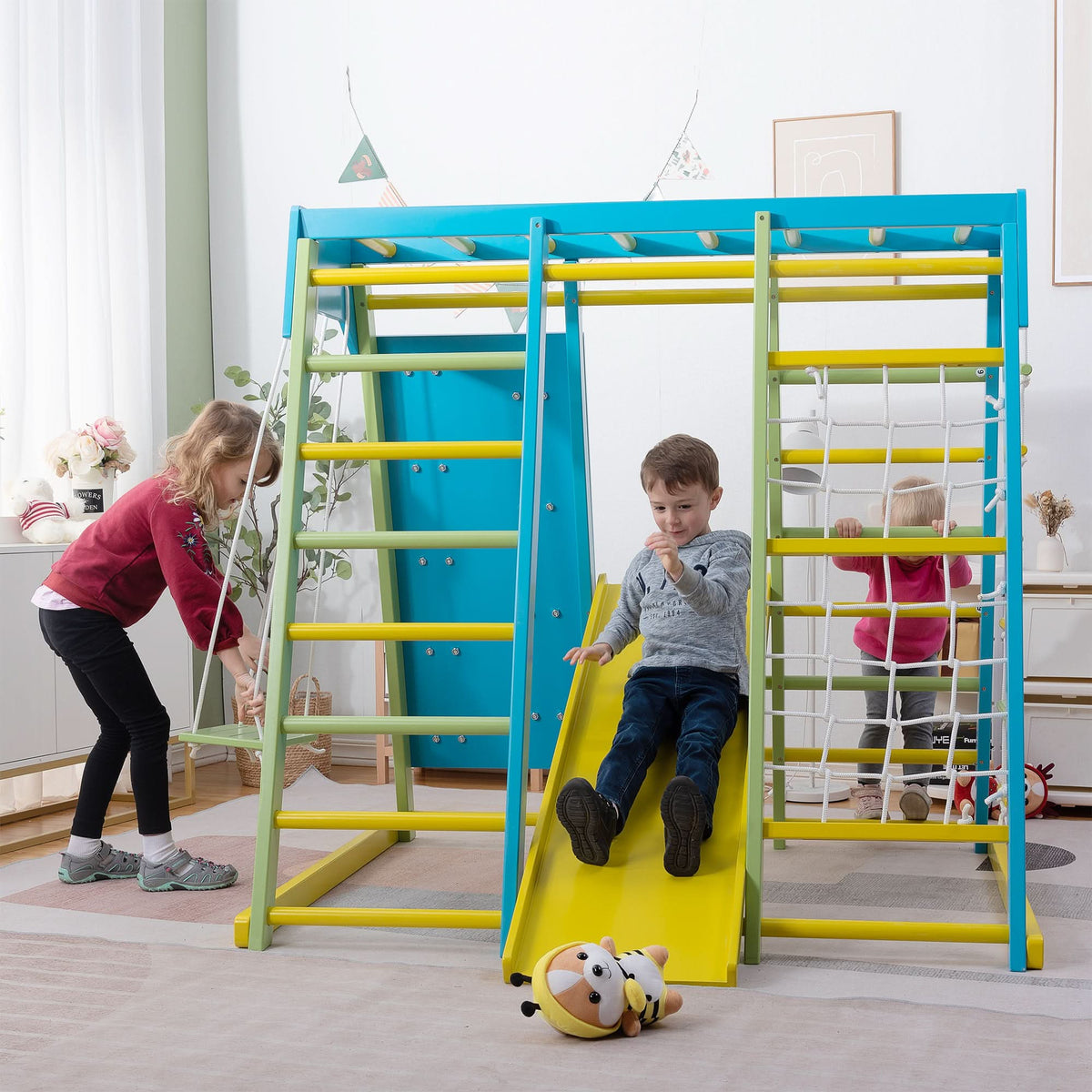 Kids playing together on the Avenlur Magnolia wooden indoor jungle gym in a bright playroom