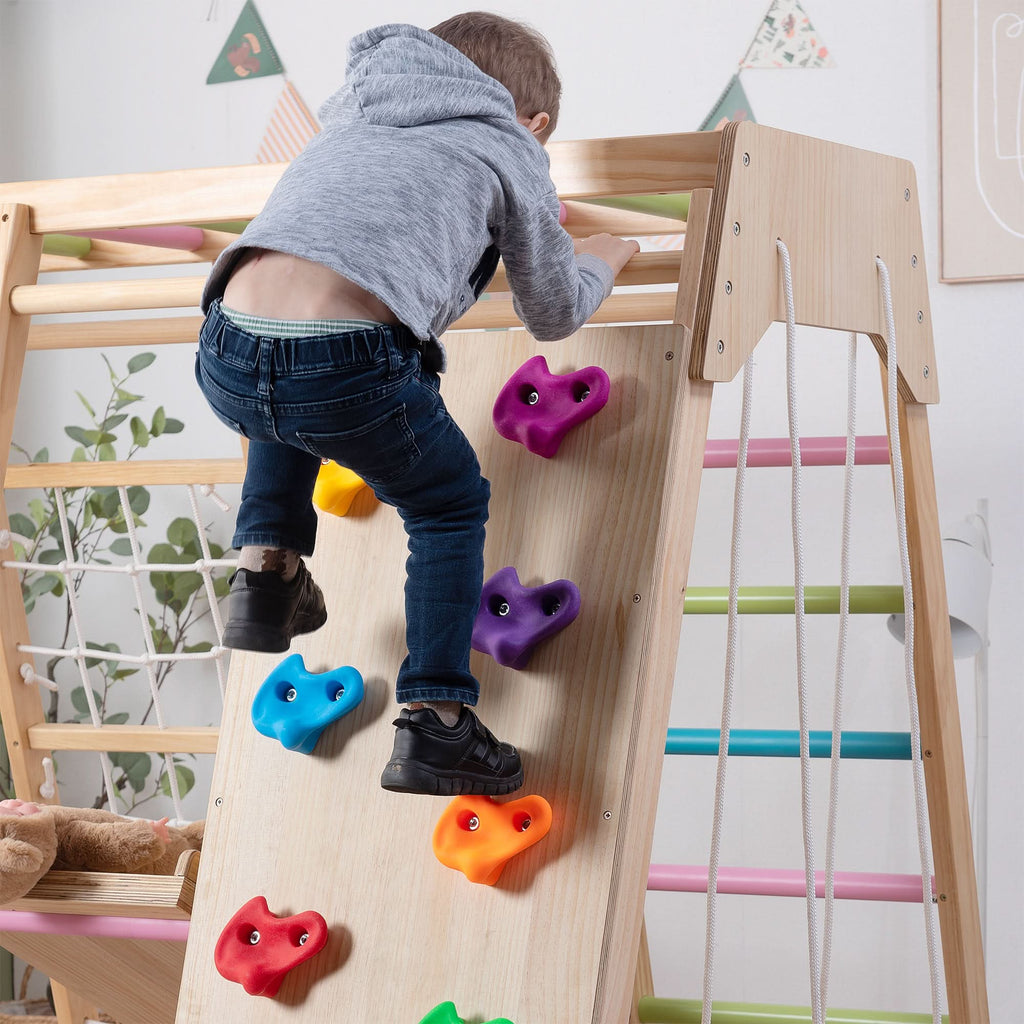 Child climbing the rock wall on the Avenlur Magnolia wooden indoor jungle gym