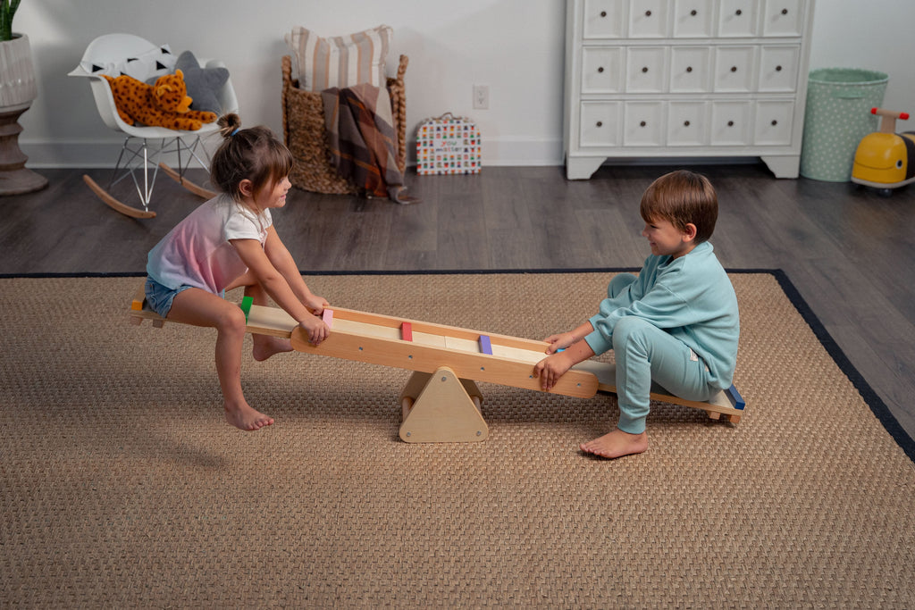 Toddler rocking on the Avenlur Willow wooden rainbow seesaw